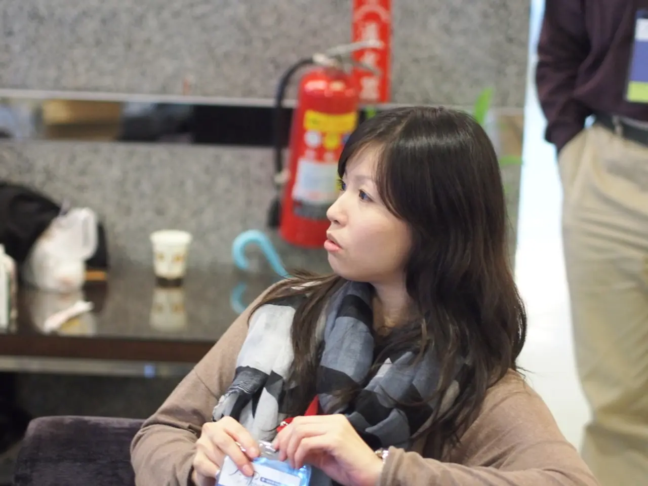 In front of the image there is a lady holding a card in her hand. Beside her on the right side...