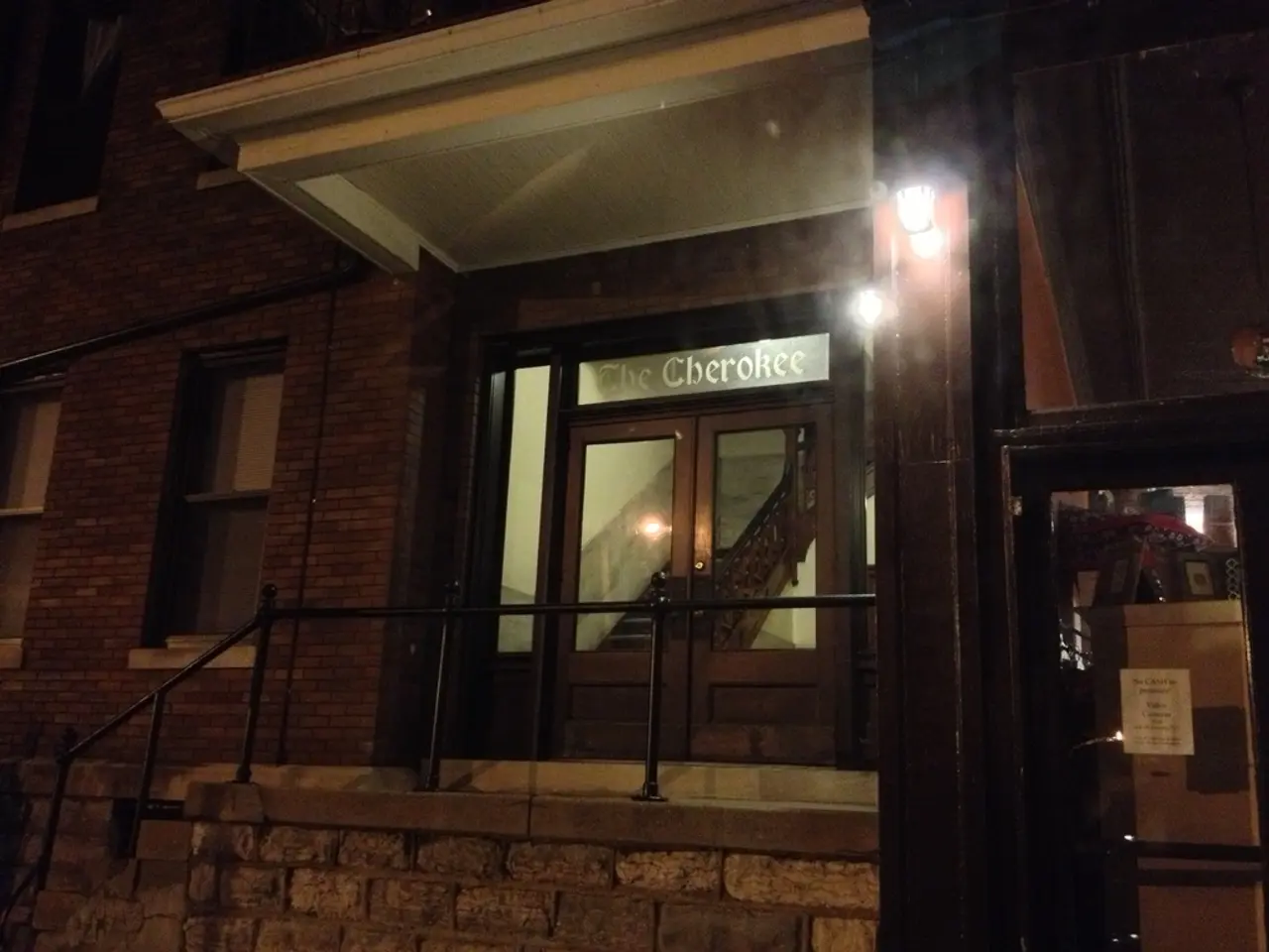 In this image I see a building on which there are windows, stairs, railing and I see the doors over...