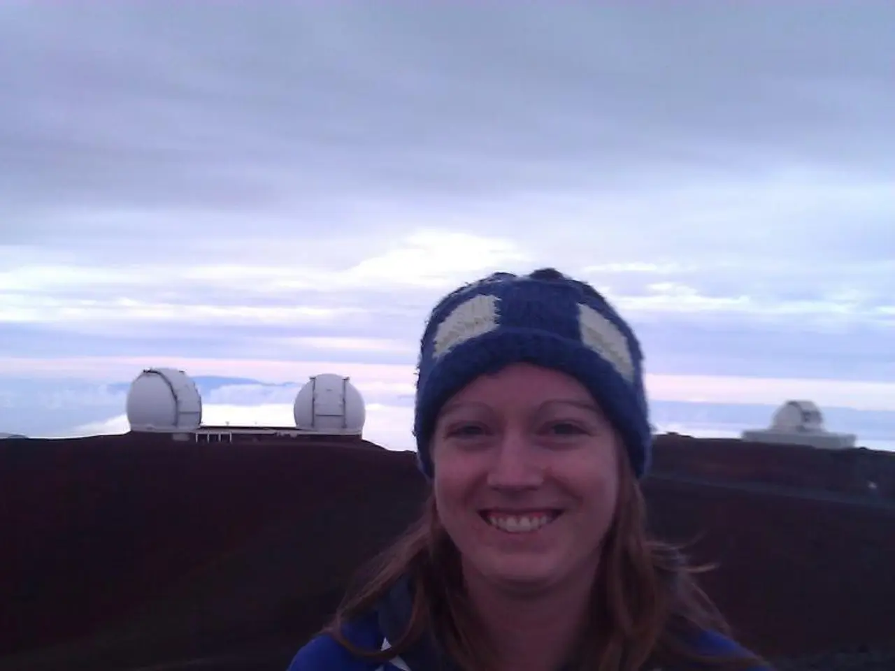 In this image I see a woman who is wearing white and blue jacket and I see that she is smiling and...