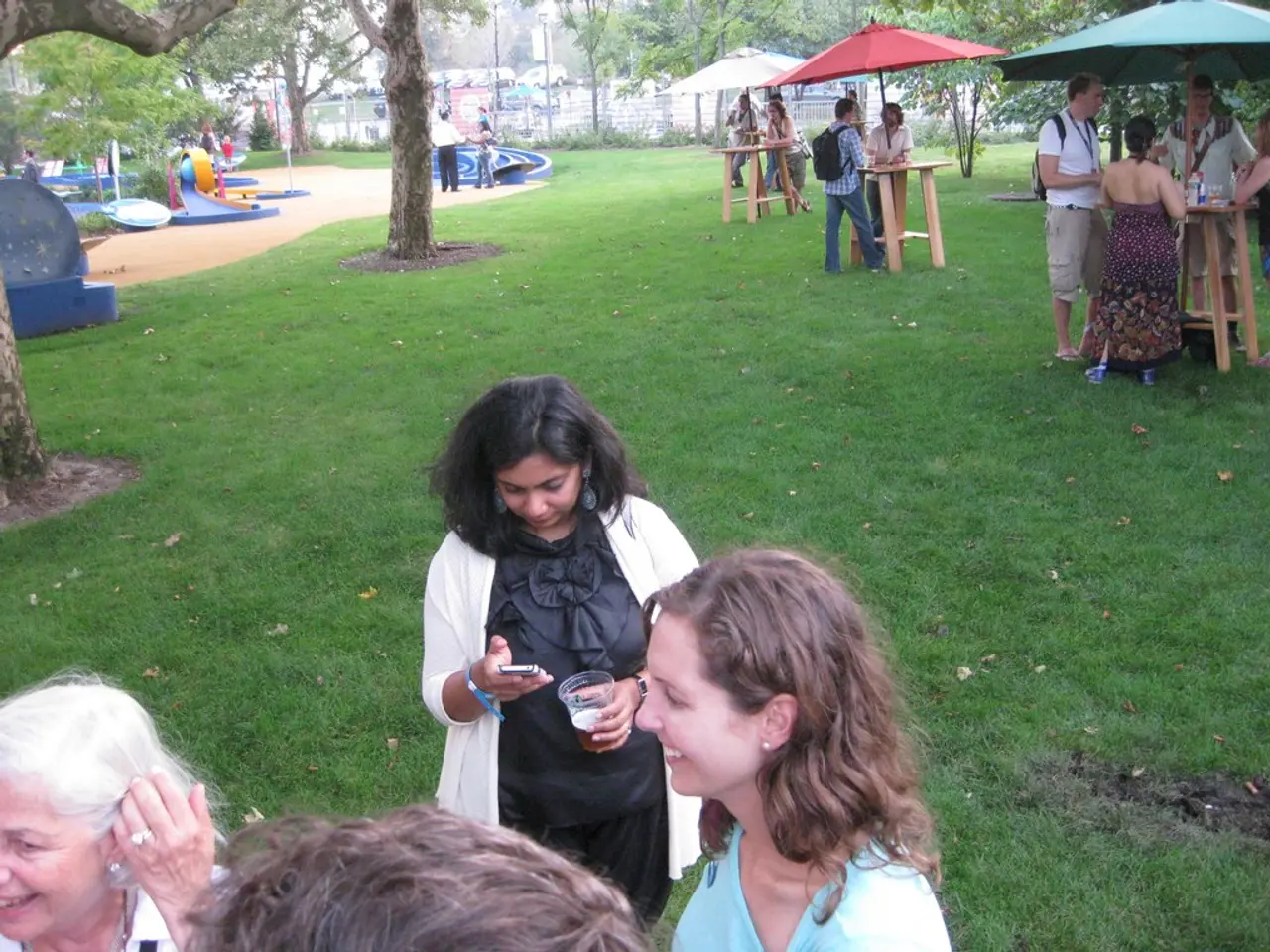 This picture is clicked outside. In the foreground we can see the group of people smiling and seems...