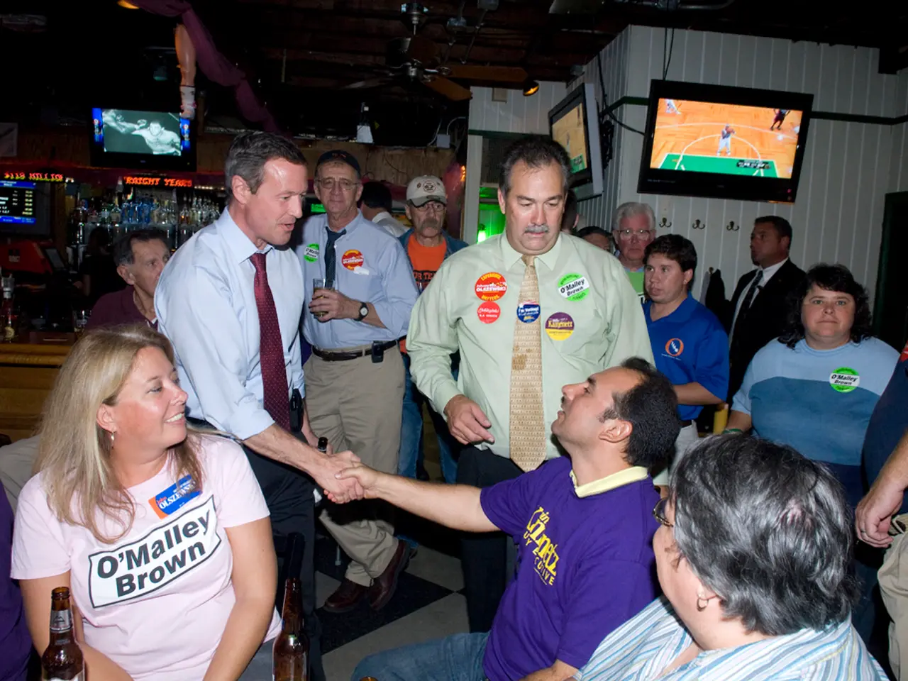 In this picture, we see three people are sitting. At the bottom of the picture, we see two glass...