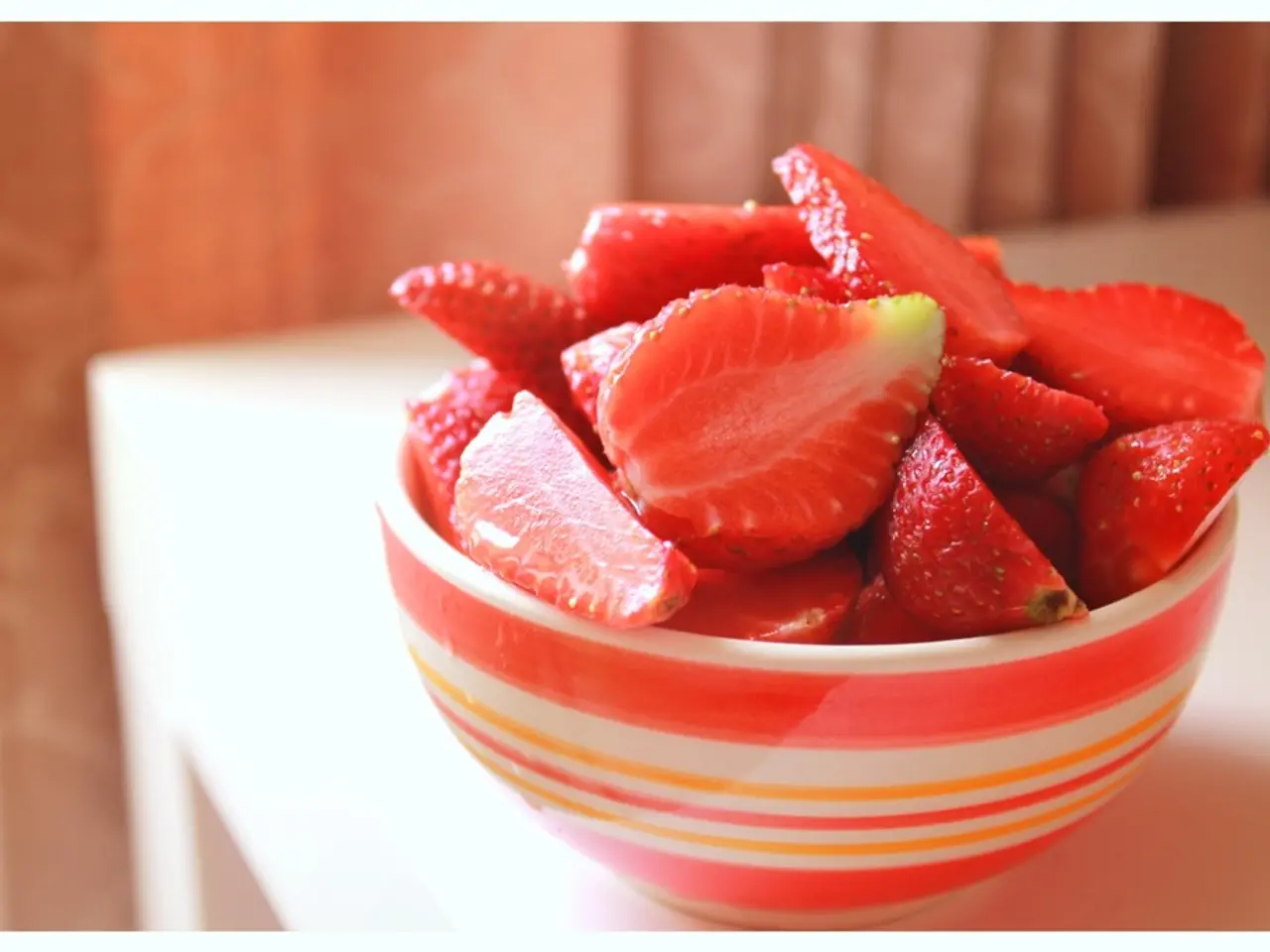 As we can see in the image there is a table. On table there is a bowl. In bowl there are strawberry...