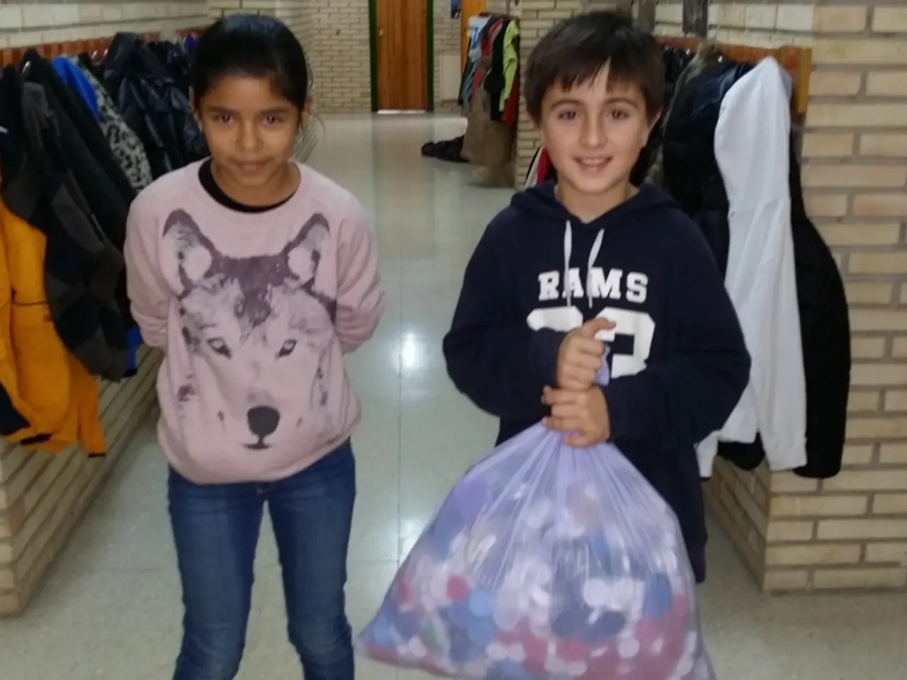 In this image I can observe a girl and a boy. The boy is holding a cover. In the background the...