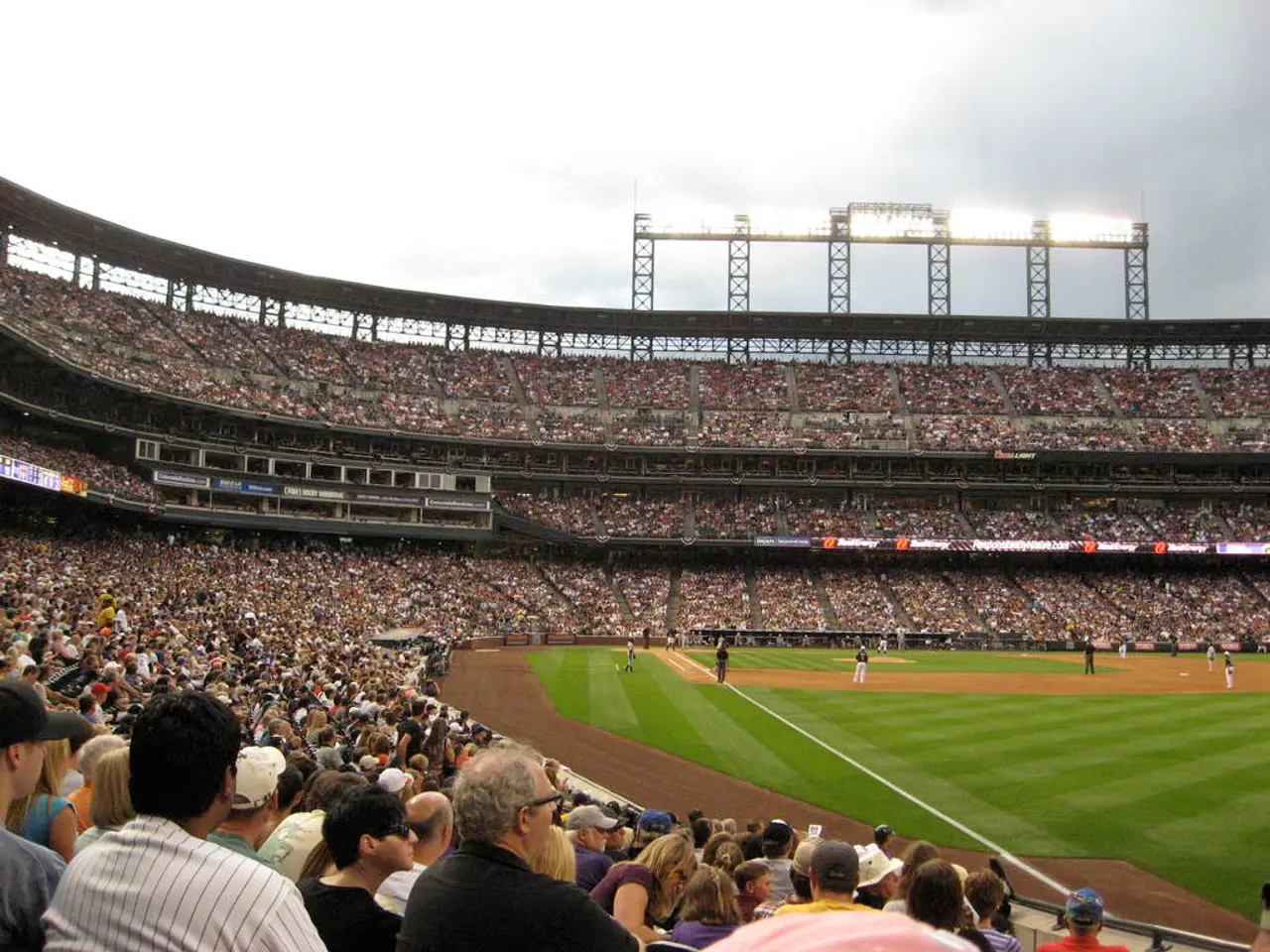 In this picture there is a view of the stadium. In the front there is a ground with some cricket...