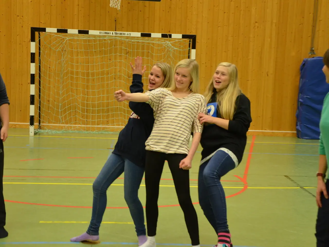 In this picture we can see five persons are standing, in the background there is a wall, we can see...