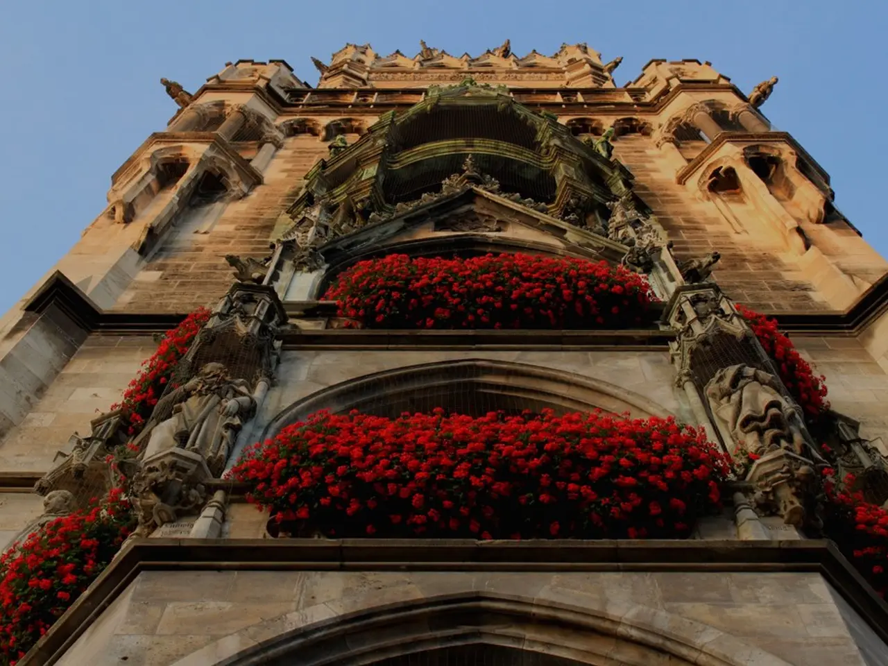 In this picture, there is a castle with statues and flowers. In the background, there is a sky.