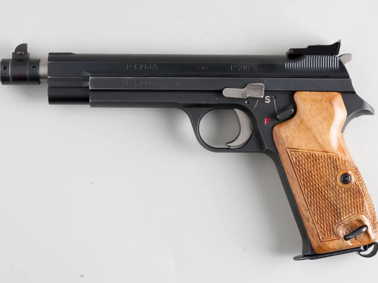 The picture consists of a gun on a white surface.