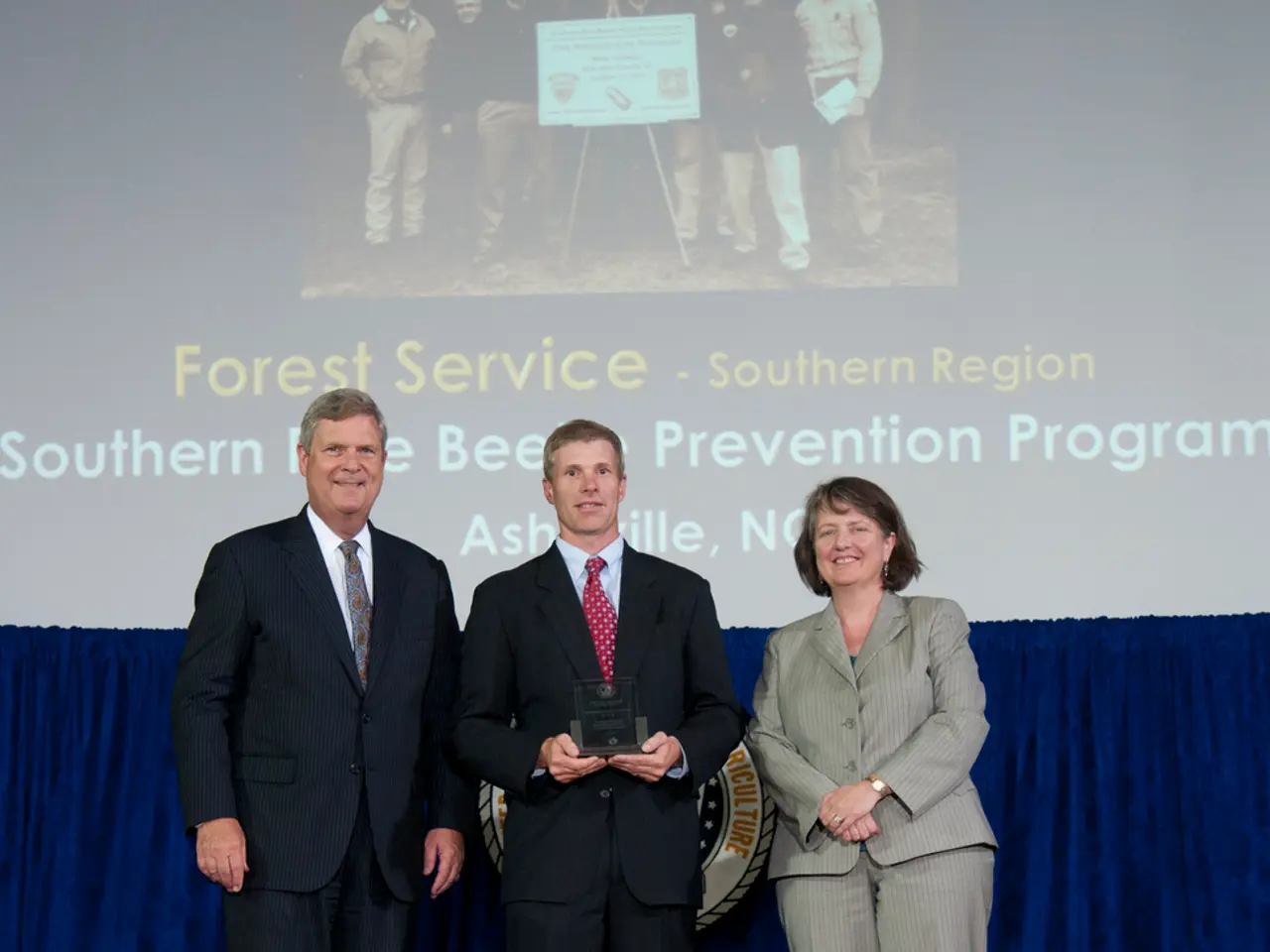 In this picture there are two men wearing black color coat, smiling and giving a pose into the...