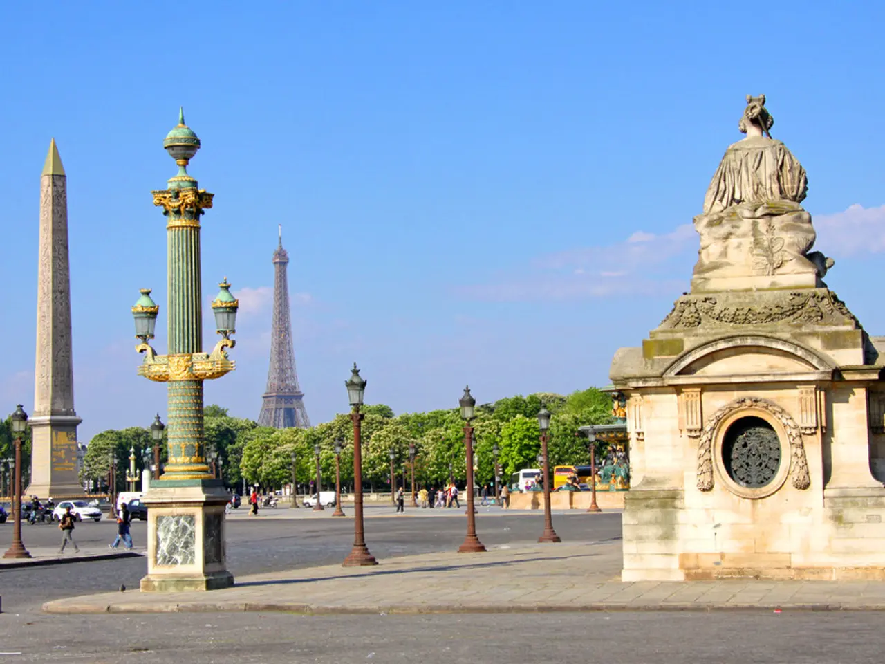 In this image I can see a sculpture. There is a tower and there is an obelisk. There are trees,...