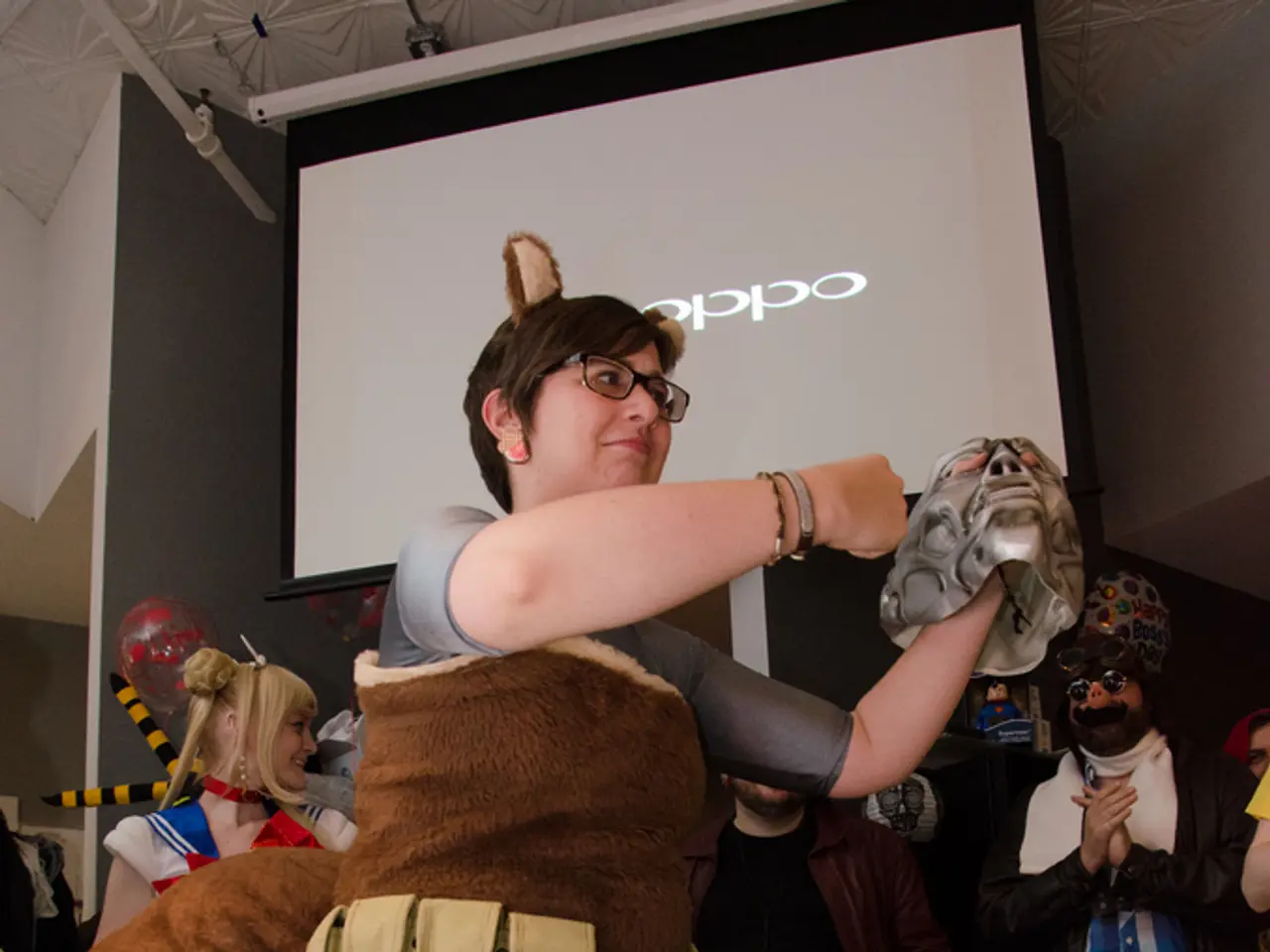 In this picture we can see a woman wearing brown color jacket holding silver mask in the hand and...