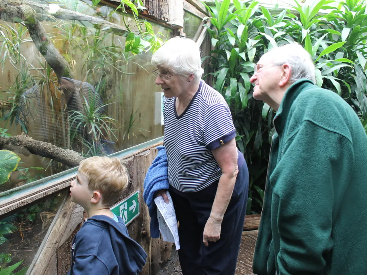 In this image there is a man and a woman and a kid, in front of them there is a glass in that glass...