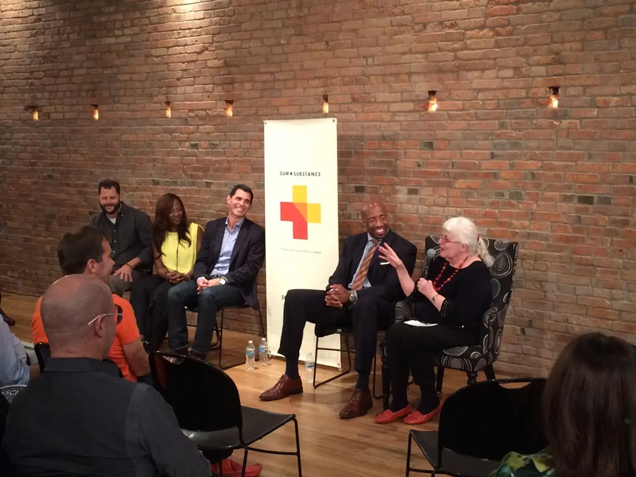 There is a room. There is a group of people. They are sitting on a chairs. They are smiling. There...