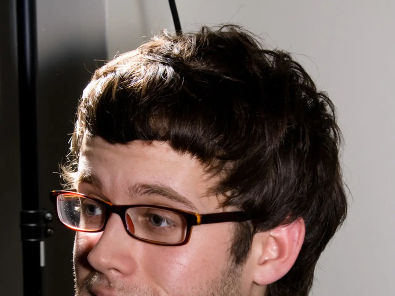 The man is highlighted in this picture. He wore spectacles and black jacket. Black rod.