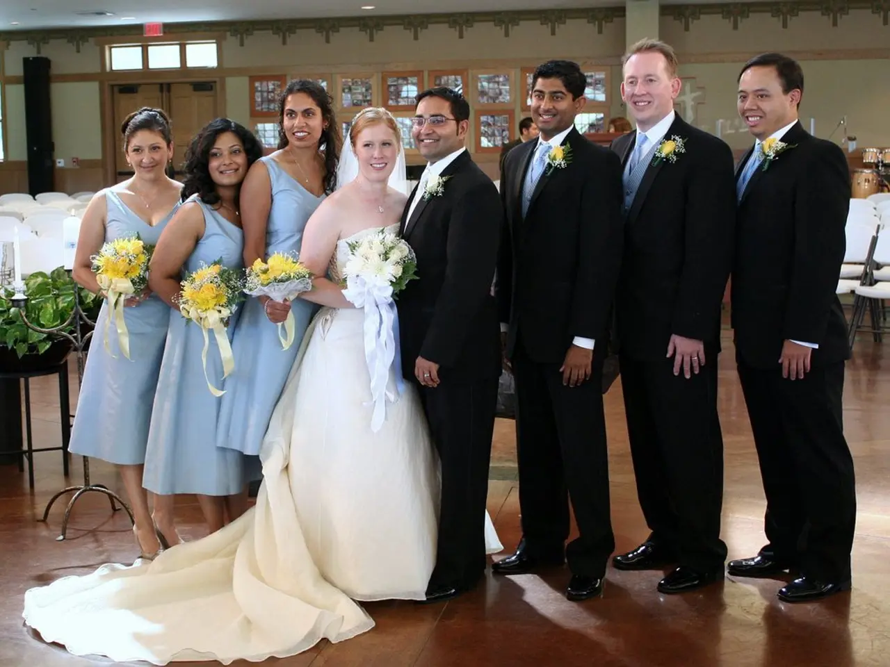 This picture is clicked inside. In the center we can see a woman wearing white color dress, holding...