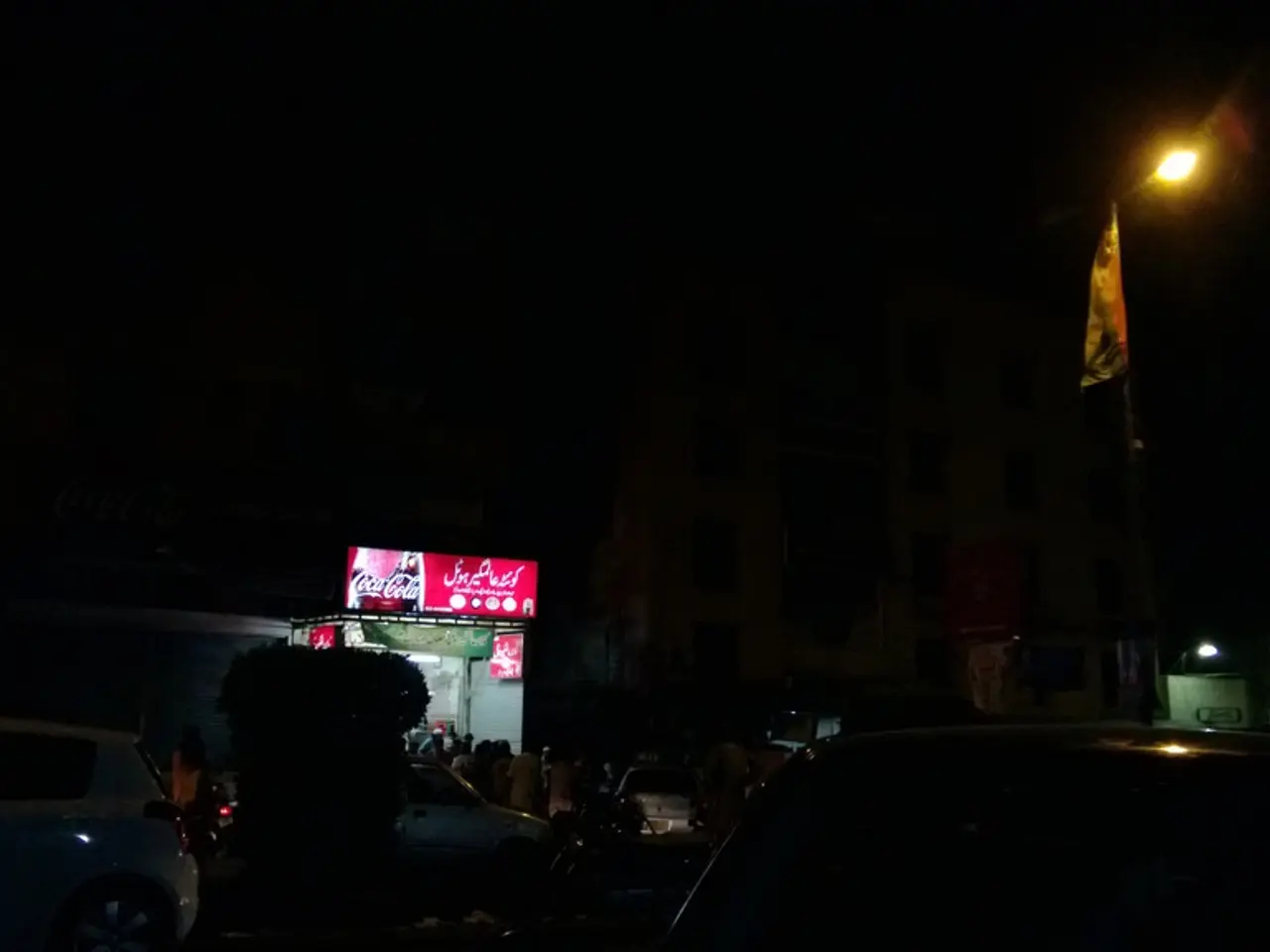 This image is taken in the nighttime. In this image there is a road on which there are cars. In the...