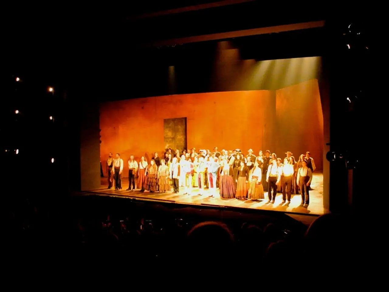 In this picture, there is a stage in the center. On the stage, there are people wearing ancient...