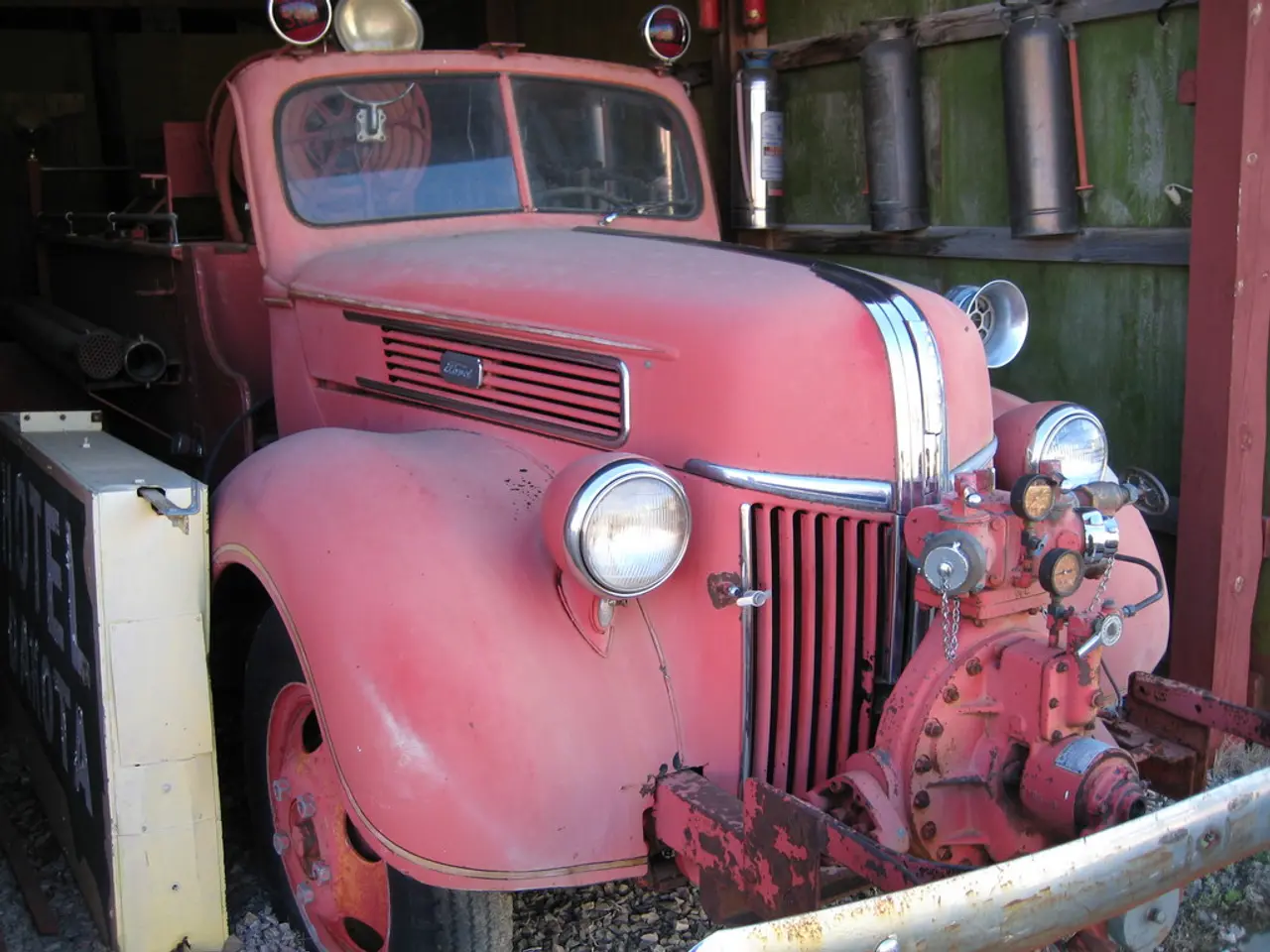 In this image we can see a motor vehicle placed on the ground with stones. Beside the motor vehicle...