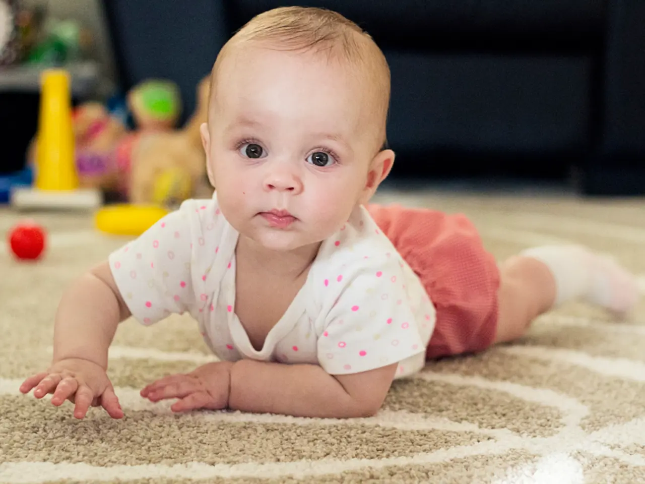 In this image I can see a baby is lying on the floor, this baby wore t-shirt, short.