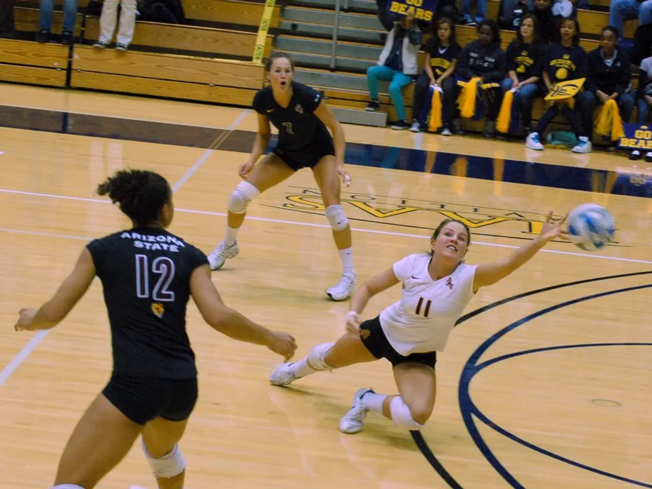 This picture is taken in a stadium. On the floor, there are three women. Among them, two are...