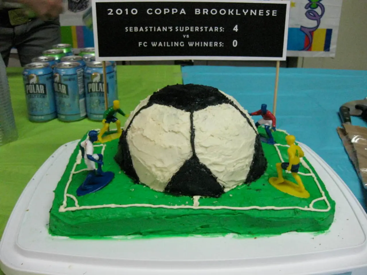 In this image there is a cake on the table. The cake looks like a football stadium in which there...
