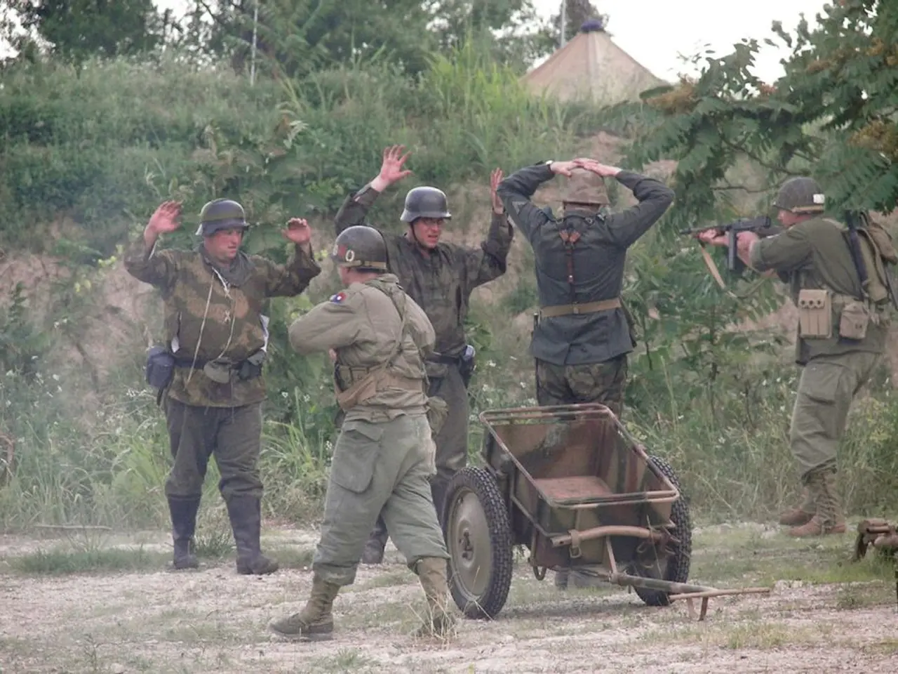 As we can see in the image there are few people wearing helmets and army dress. There is a cart,...