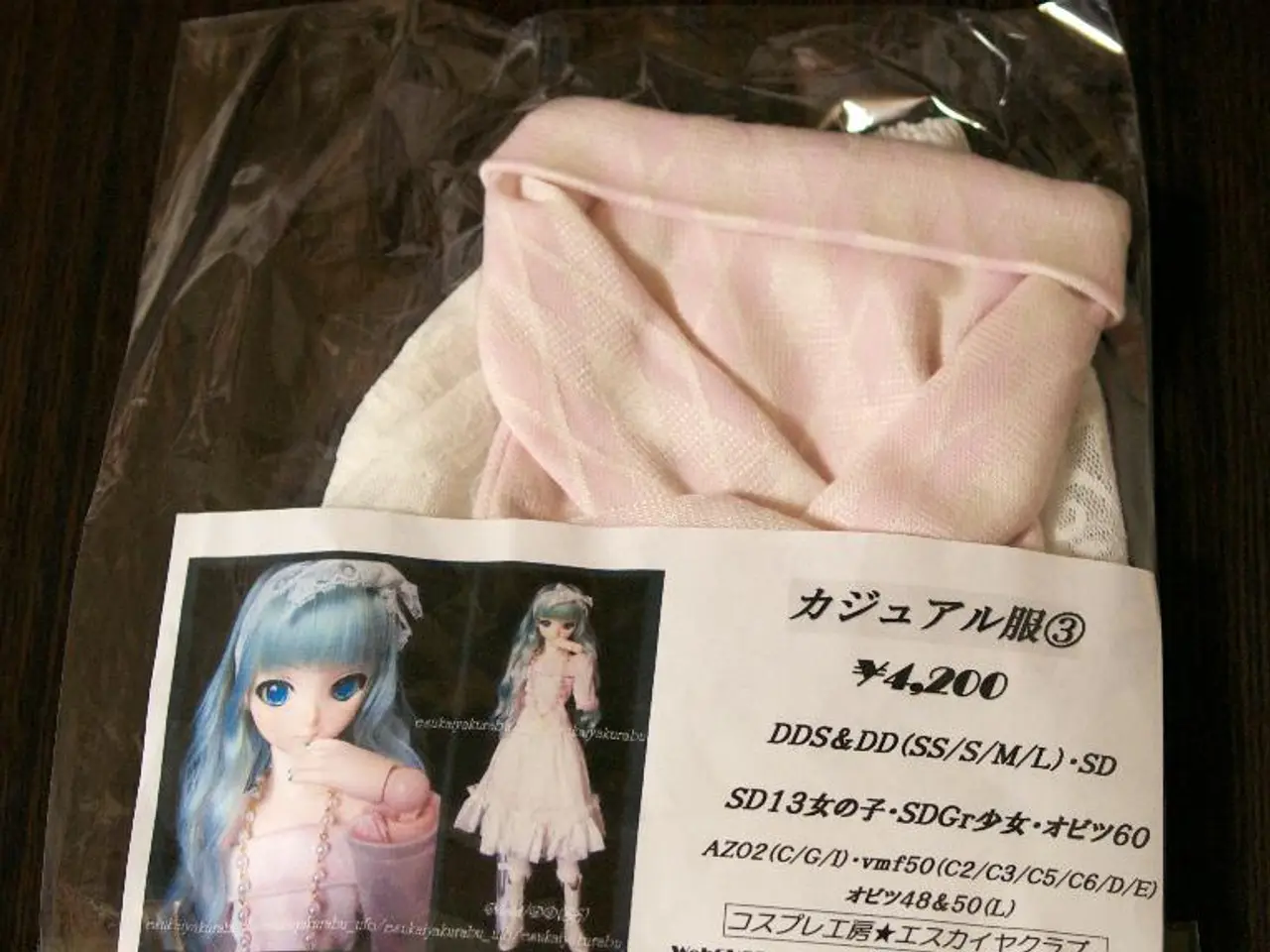 In this image we can see a dress in the cover. There is a label on the cover. We can see a photo of...