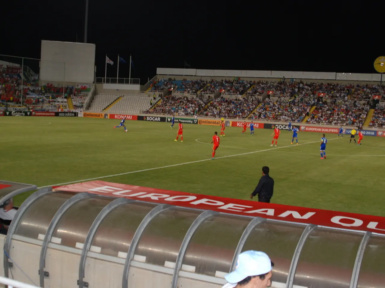 In this image, we can see some persons playing football. There is a crowd in the middle of the...