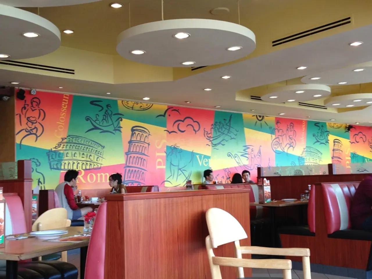 There are group of people sitting in restaurant and there is a server in the right in the right...