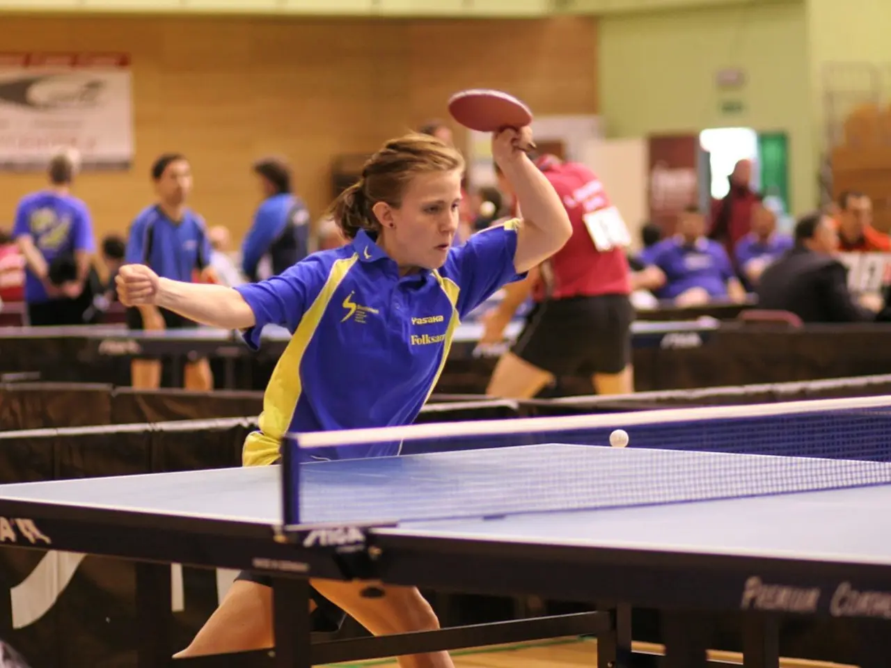 This woman is highlighted in this picture. She holds a bat and plays a table tennis. Far few...