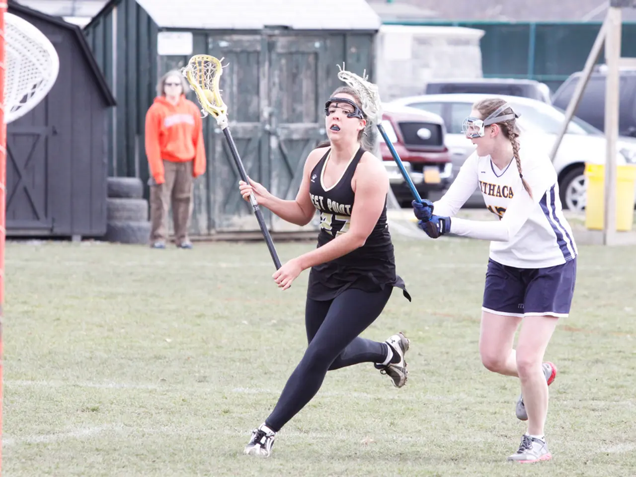 In this picture both the women are running with holding stick in their hands and on left side woman...