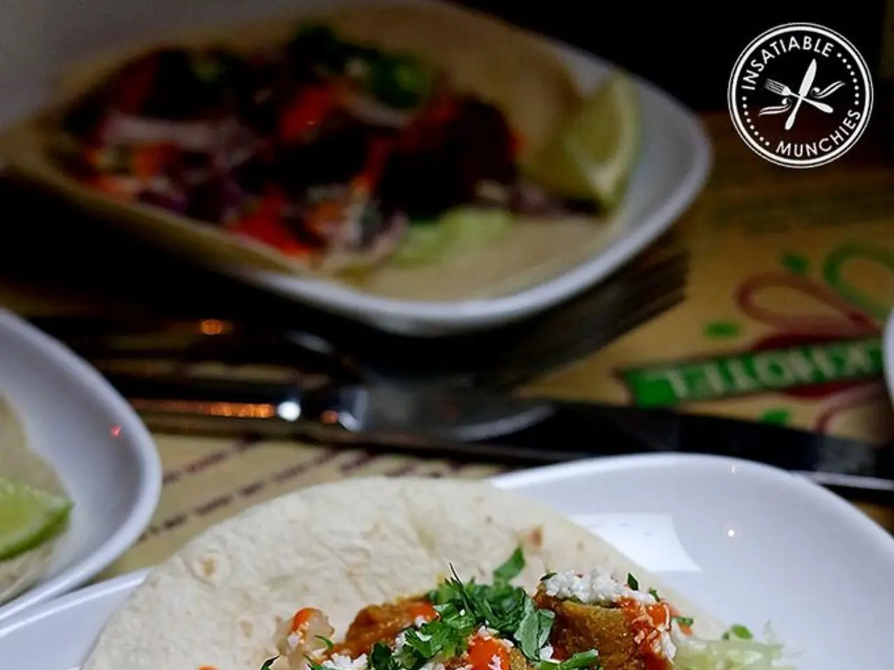 In this image we can see food items in plates on the table. There is a knife. To the top right...