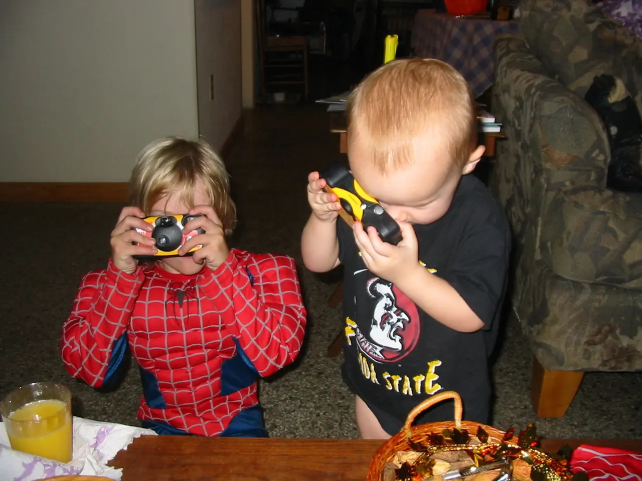 In the picture I can see two children and they are holding the toy camera in their hands. There is...