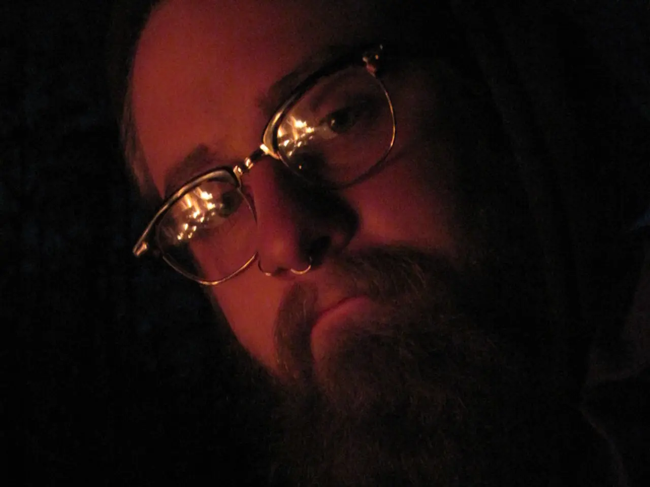 This describe about close view of the men wearing specs with big beard is giving a pose into the...