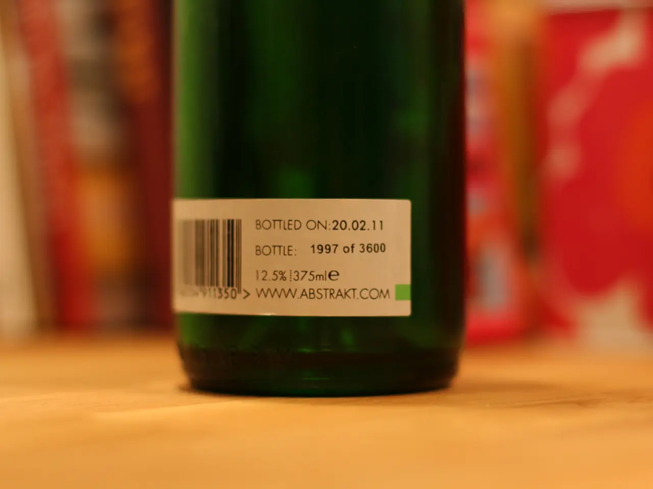 In this image we can see there is a label with some text on the bottle which is on the table.