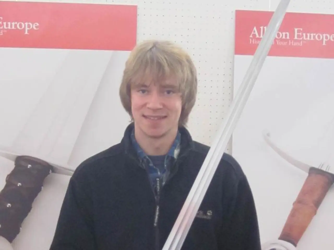 In the center of the image we can see a man standing and holding a sword. At the bottom there is a...