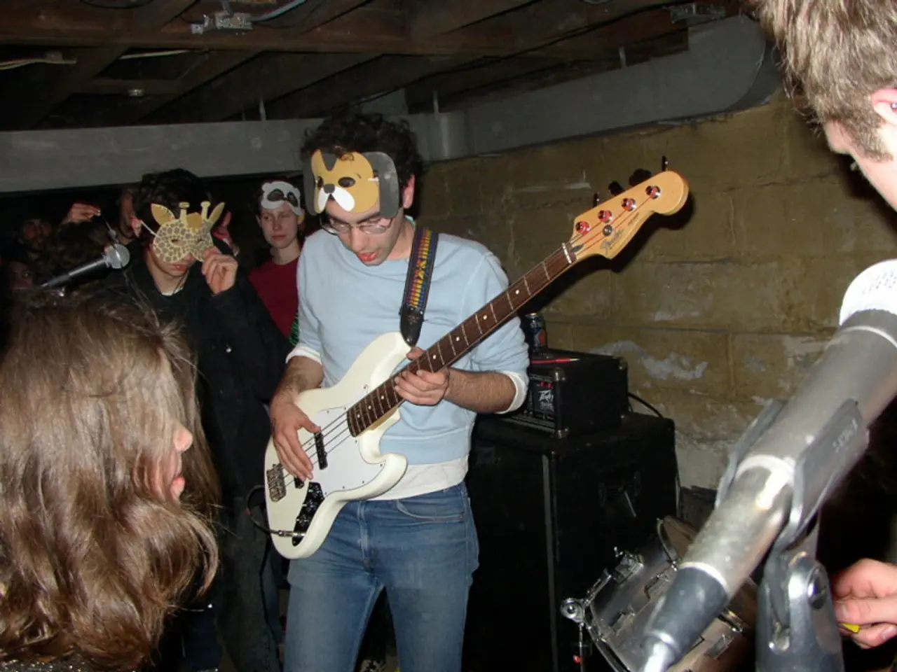 In this image there are group of people one person is holding a guitar, and some of them are...