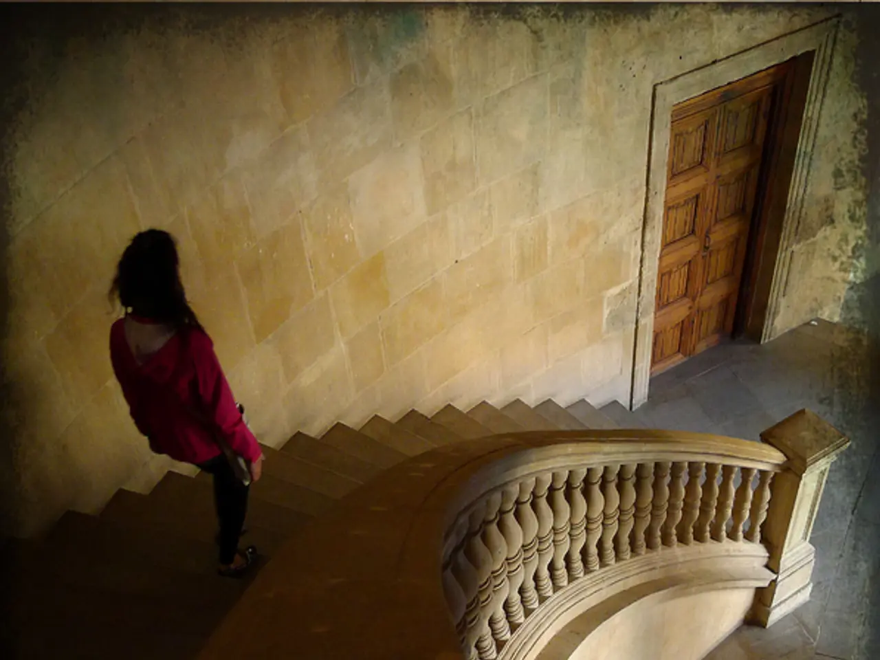 This picture describes about inside view of a building, in this we can see a woman and few stairs.