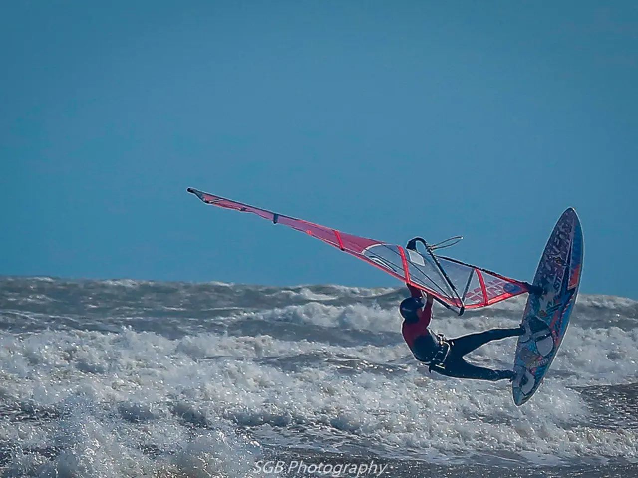 In this image there is a person surfing on the water.