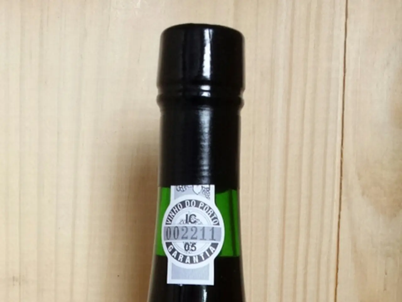 In this image there is a beer bottle with the labels on the wooden path.