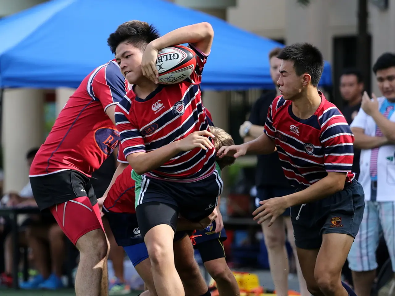 This picture is taken in the ground, There are some people playing a game, In the middle there is a...