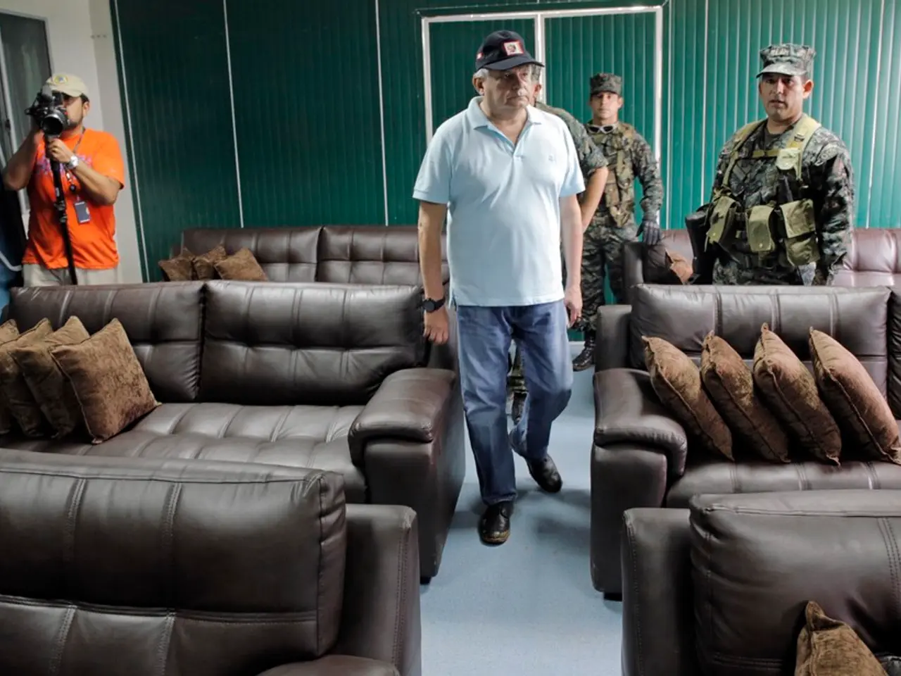 Here we can see group of military people standing and at the left side there is a person with video...