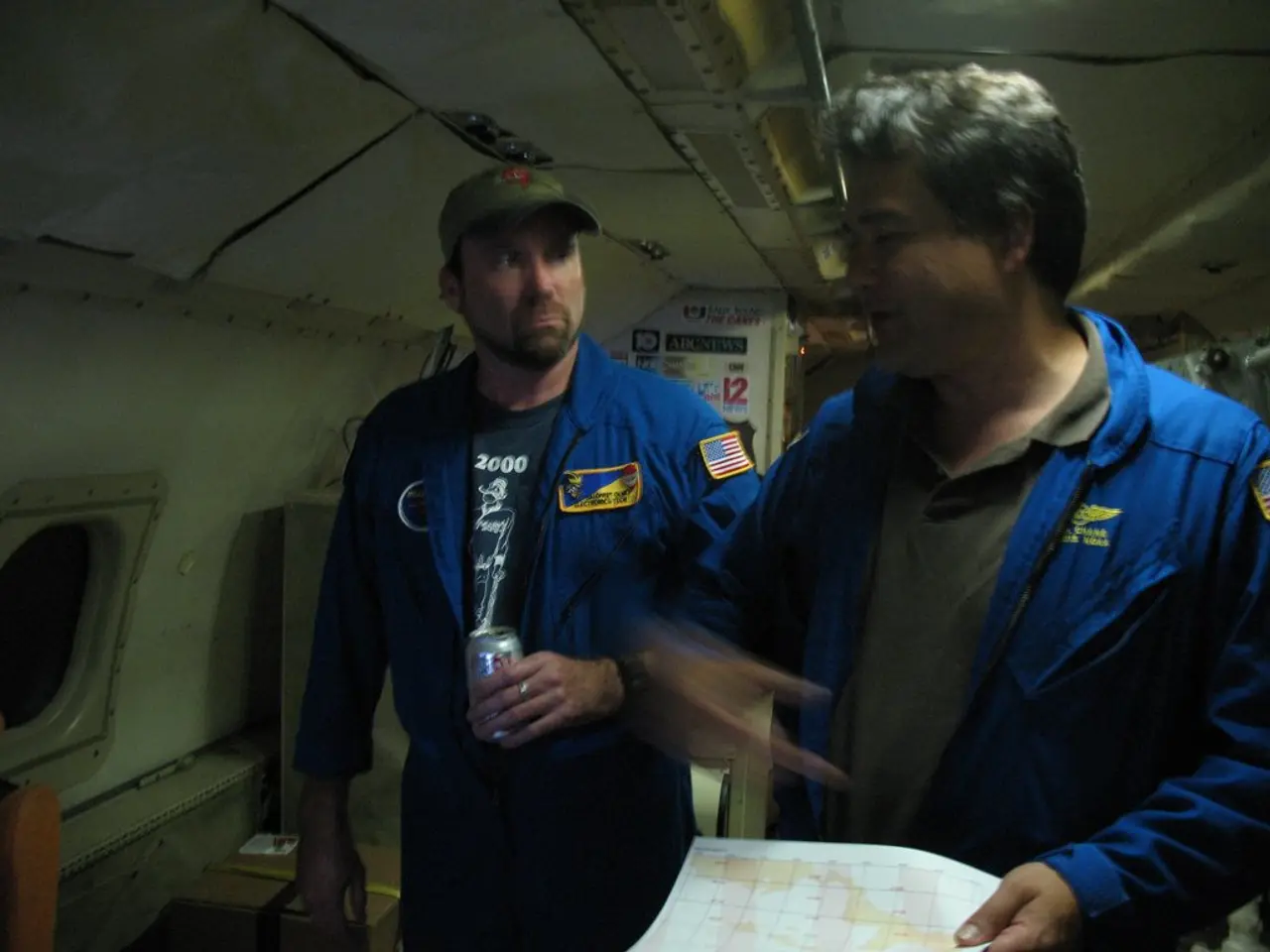 In the center of the image we can see two persons wearing blue color jacket. To the left side of...