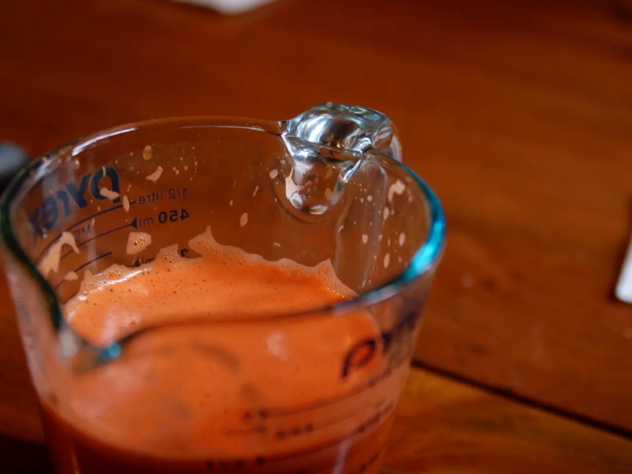 In this image there is a jar and in the jar there is juice, at the bottom there is a table and...