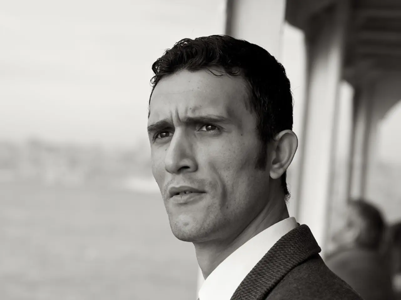 In this image in the foreground there is one person, and in the background there is another person...