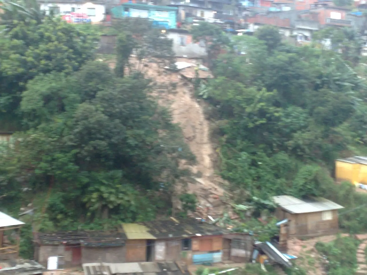 In this picture there are some trees, a mountain and a building.