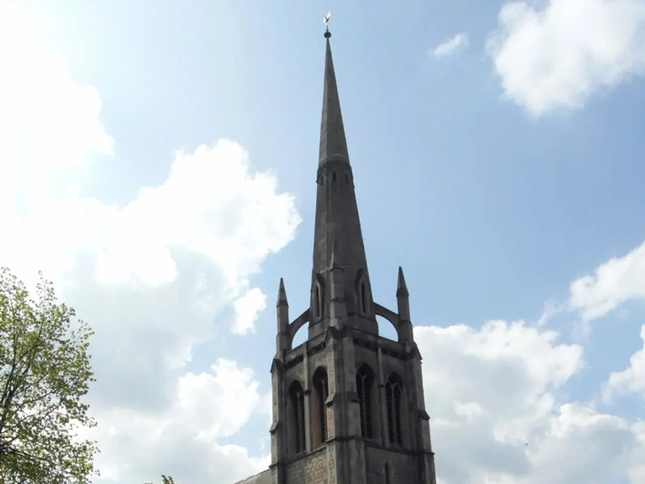 In the image there is a church in the back with a road in front of it followed by buildings beside...