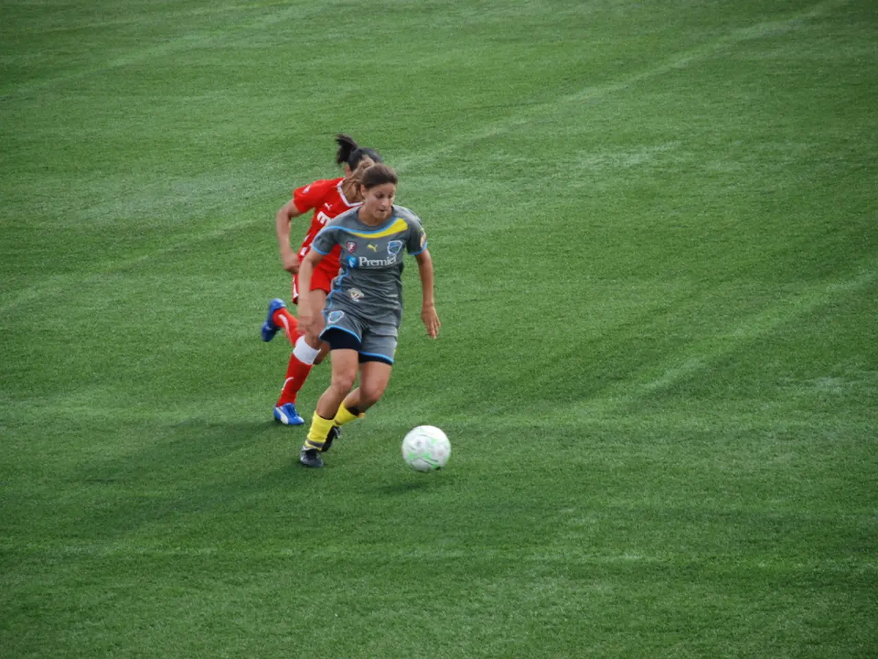 In this image we can see women and ball on the ground.