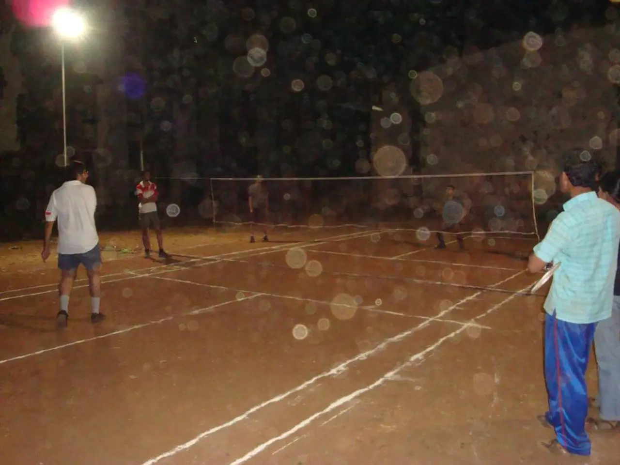 In the image there is a street light on the left side corner and few men playing volleyball on the...