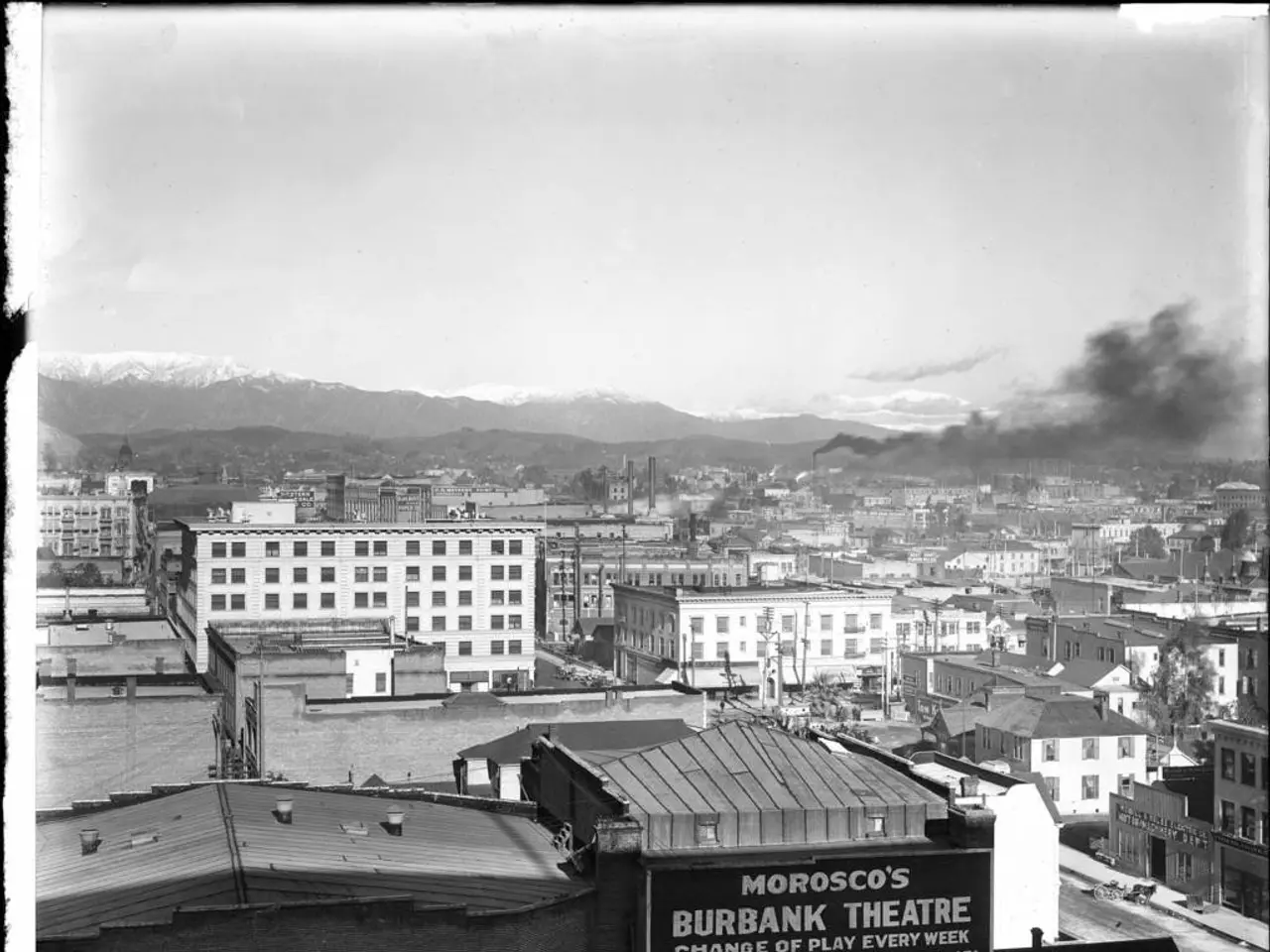 In the image we can see there are buildings and there is a factory. There is a smoke coming out of...