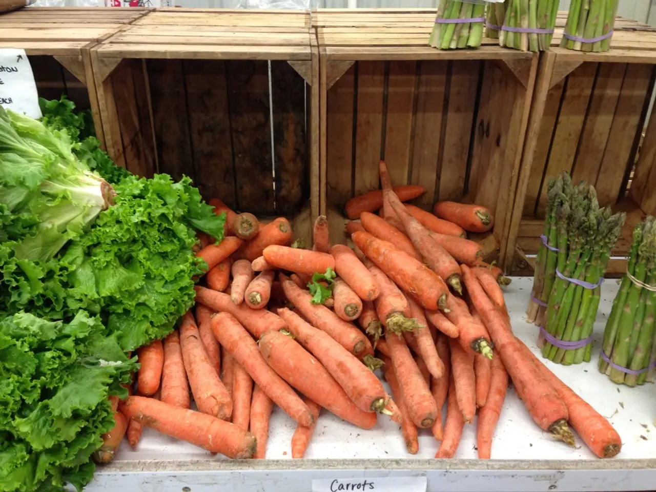 At the bottom of the image we can see a table. On the table we can see the carrots, leafy...
